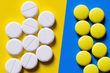 top view of round shape pills on blue and yellow background clipart