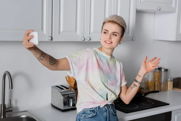 Smiling Tattooed Woman Taking Selfie Cellphone Kitchen — Φωτογραφία Αρχείου