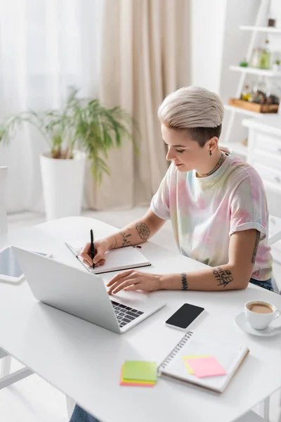 Stylish Woman Writing Notebook Gadgets Coffee Cup Kitchen Table — Zdjęcie stockowe