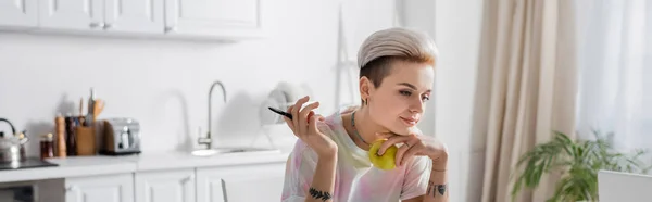 Tattooed Woman Trendy Hairstyle Holding Pen Fresh Apple Blurred Kitchen — 스톡 사진