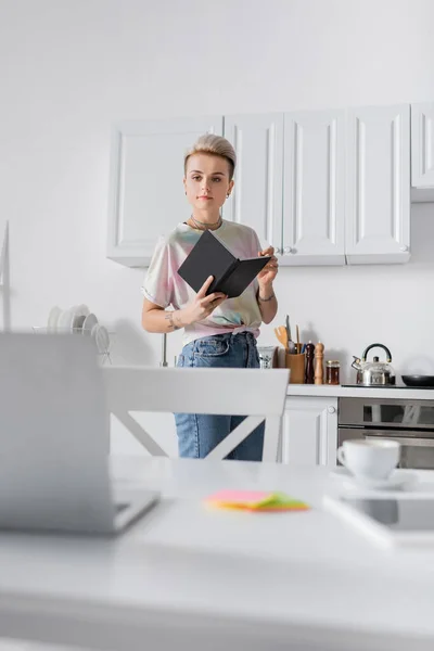 Stylish Woman Standing Notebook Kitchen Looking Blurred Laptop — стоковое фото