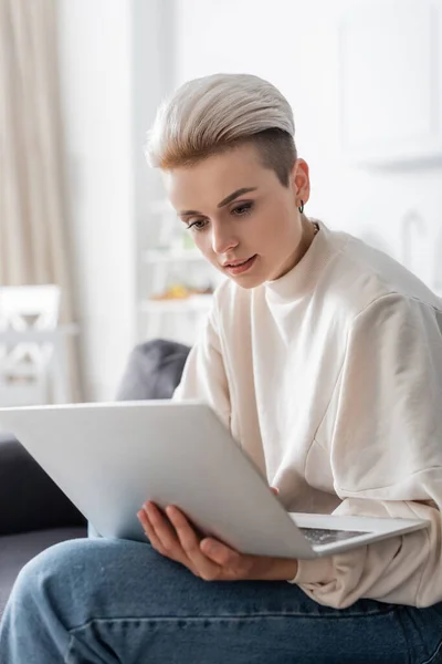 Genç Şık Bir Kadın Evde Otururken Dizüstü Bilgisayara Bakıyor — Stok fotoğraf