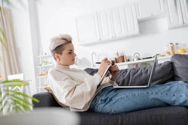 Side View Woman Writing Notebook Laptop Sofa Home — Photo