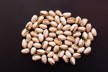 top view of pile with salty pistachios isolated on black 