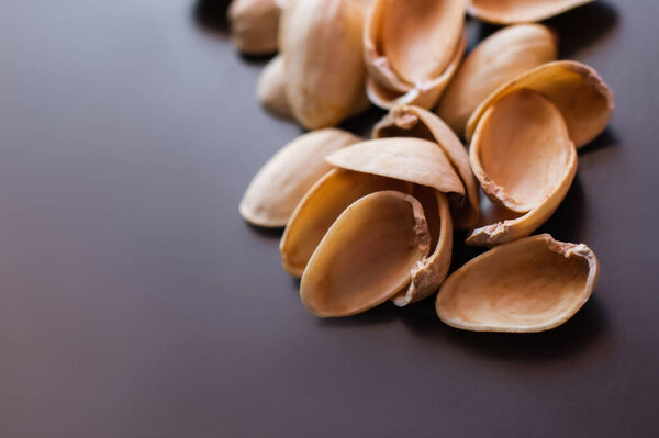 close up view of shells form pistachio nuts on black 