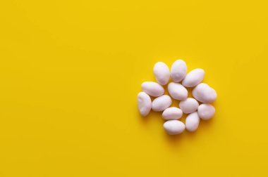 top view of peeled pine nuts on yellow background