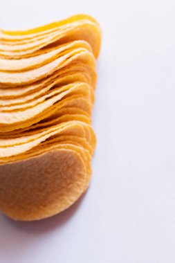 close up view of salty and crunchy potato chips on white
