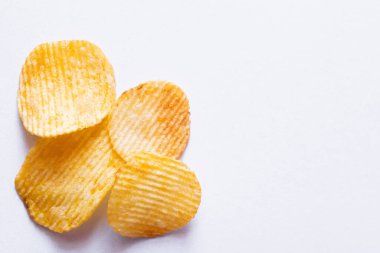 top view of wavy and salty potato chips on white clipart