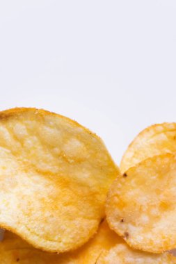 close up view of delicious and salty potato chips on white
