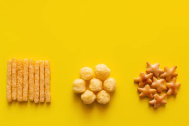 top view of tasty french fries, cheese pops and bakes star shape cookies on yellow