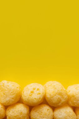 top view of puffed and tasty cheese pops on yellow
