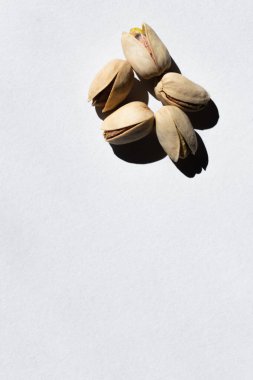 top view of cracked and healthy pistachio nuts on white clipart