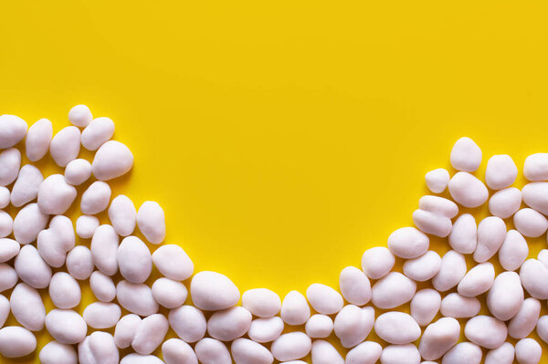 flay lay of peeled pine nuts on yellow background