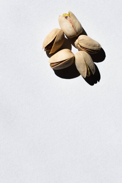 top view of cracked and healthy pistachio nuts on white
