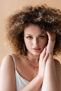 Bej renginde izole edilmiş kıvırcık model dokunuşunun portresi 