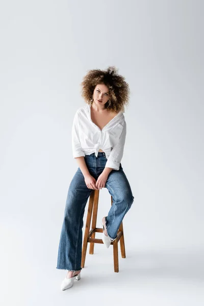 Model Keriting Dalam Blus Duduk Kursi Pada Latar Belakang Putih — Stok Foto