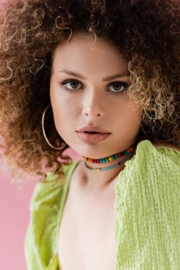 Pembeye izole edilmiş yeşil bluzlu kıvırcık modelin portresi 