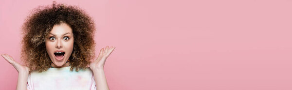 Amazed woman looking at camera isolated on pink, banner 