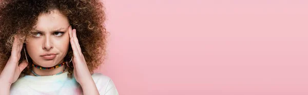 ピンク バナーに隔離された頭に触れる可愛い巻き女性 — ストック写真