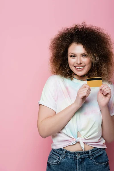 穿着T恤 背景为粉红 手握信用卡的快乐女人 — 图库照片