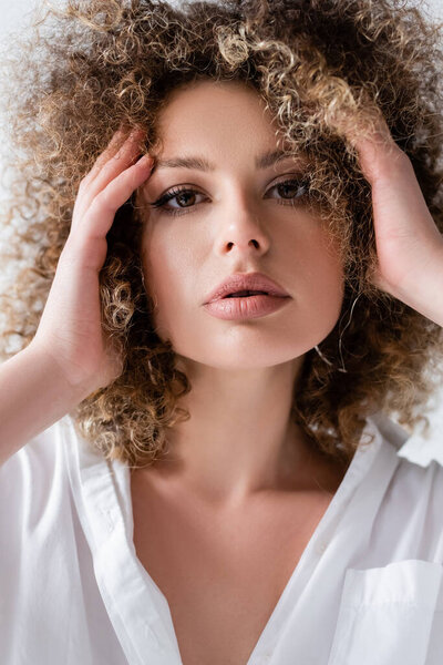 Portrait of woman in blouse touching forehead isolated on white 