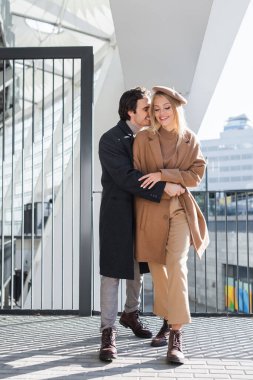 Şehir caddesinde trend kadınlara sarılan genç bir adam.