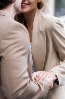 Alyansla gülümseyen kadının el ele tutuşan bir adam görüntüsü. 