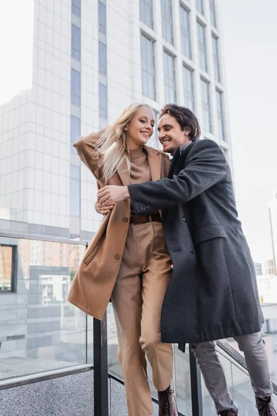 Giovane Uomo Cappotto Abbracciando Donna Alla Moda Mentre Cammina Città — Foto Stock