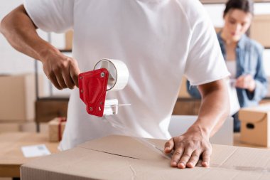 Çevrimiçi web mağazasında yapıştırıcı bantlı Afrika kökenli Amerikalı paketleme kutusu 