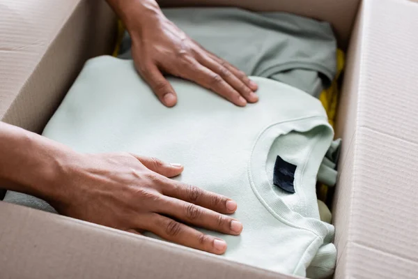Cropped View African American Seller Putting Clothes Package Online Web — Stock Photo, Image