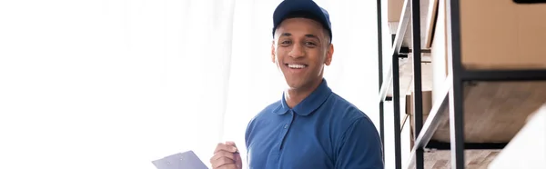 Positive African American Deliveryman Uniform Holding Clipboard Looking Camera Boxes — Stock Photo, Image