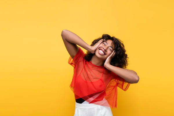 Feliz Afro Americana Tocando Rosto Enquanto Sorri Com Olhos Fechados — Fotografia de Stock