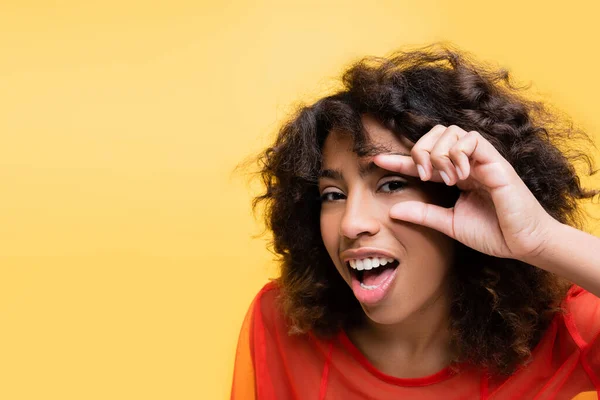 Espantado Curioso Afro Americano Mulher Mostrando Peeping Gesto Isolado Amarelo — Fotografia de Stock