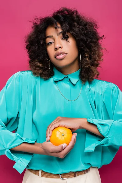 Mujer Afroamericana Blusa Cyan Moda Sosteniendo Naranja Madura Aislada Rosa —  Fotos de Stock