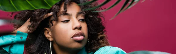 African American Woman Touching Wavy Hair Looking Away Green Leaves — Stock Photo, Image