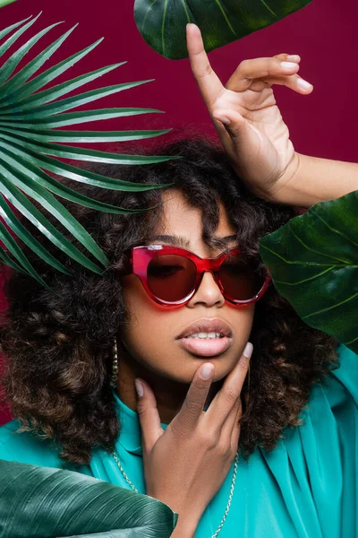 African American Woman Sunglasses Touching Face Pointing Finger Leaves Isolated — Stock Photo, Image