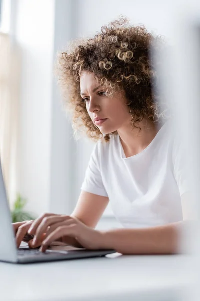 Donna Concentrata Con Capelli Ondulati Digitando Sul Computer Portatile Primo — Foto Stock