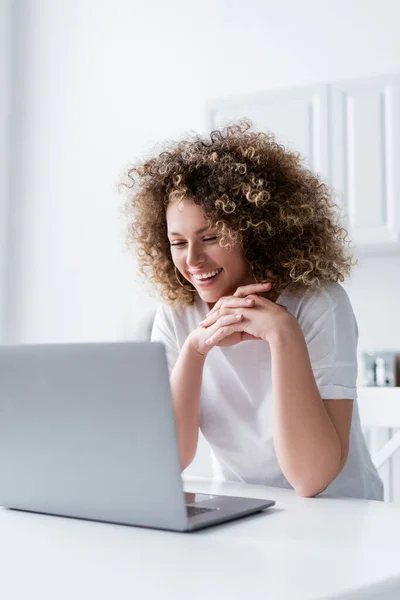 Happy Curly Woman Clenched Hands Looking Laptop Kitchen — Stock Photo, Image