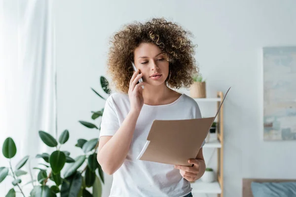 Mujer Con Pelo Ondulado Celebración Carpeta Durante Conversación Teléfono Móvil — Foto de Stock