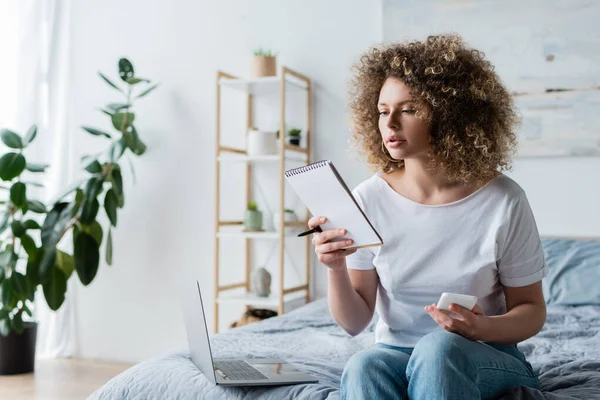 Curly Woman Smartphone Notebook Sitting Bed Laptop — Stock Photo, Image