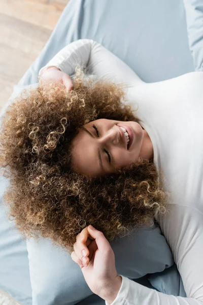 Top View Cheerful Curly Woman Closed Eyes Stretching Bed Home — Stock Photo, Image