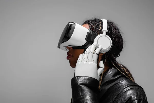 Vista Lateral Mujer Afroamericana Con Mano Robótica Auriculares Escuchando Música — Foto de Stock