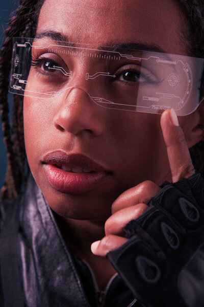 Portrait of african american woman in glove and smart glasses isolated on dark blue 