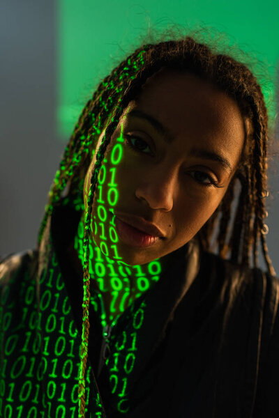 Portrait of african american woman with binary code on face on grey background 
