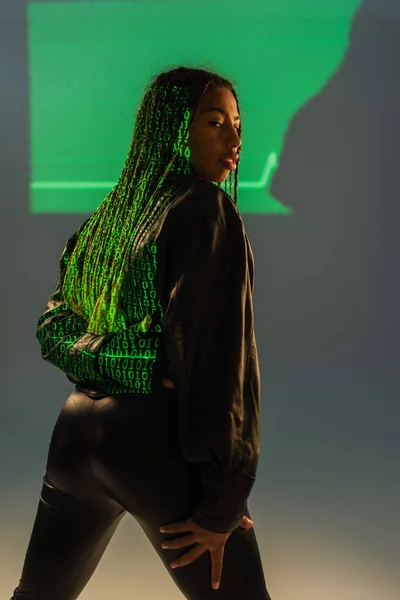 在灰色背景的皮夹克上投射计算机代码的时尚非洲裔美国女人 — 图库照片
