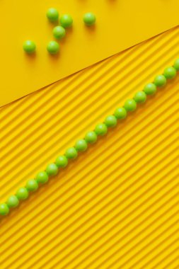 Çizginin üst görüntüsü ve yeşil topların dokulu sarı arkaplan üzerine dağılması