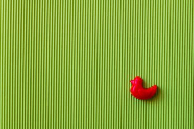 Yeşil desenli arka planda ördek şeklinde kırmızı küf manzarası