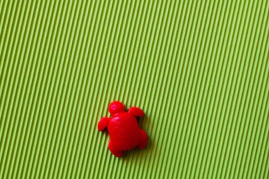 top view of red turtle sand mold on green corrugated background clipart