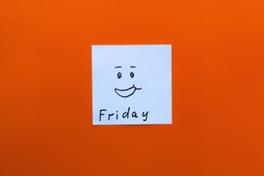 top view of card with friday lettering and happy emoticon on orange background clipart