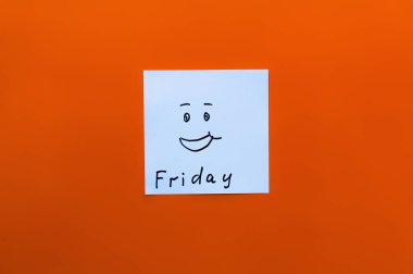 top view of card with friday lettering and happy emoticon on orange background clipart